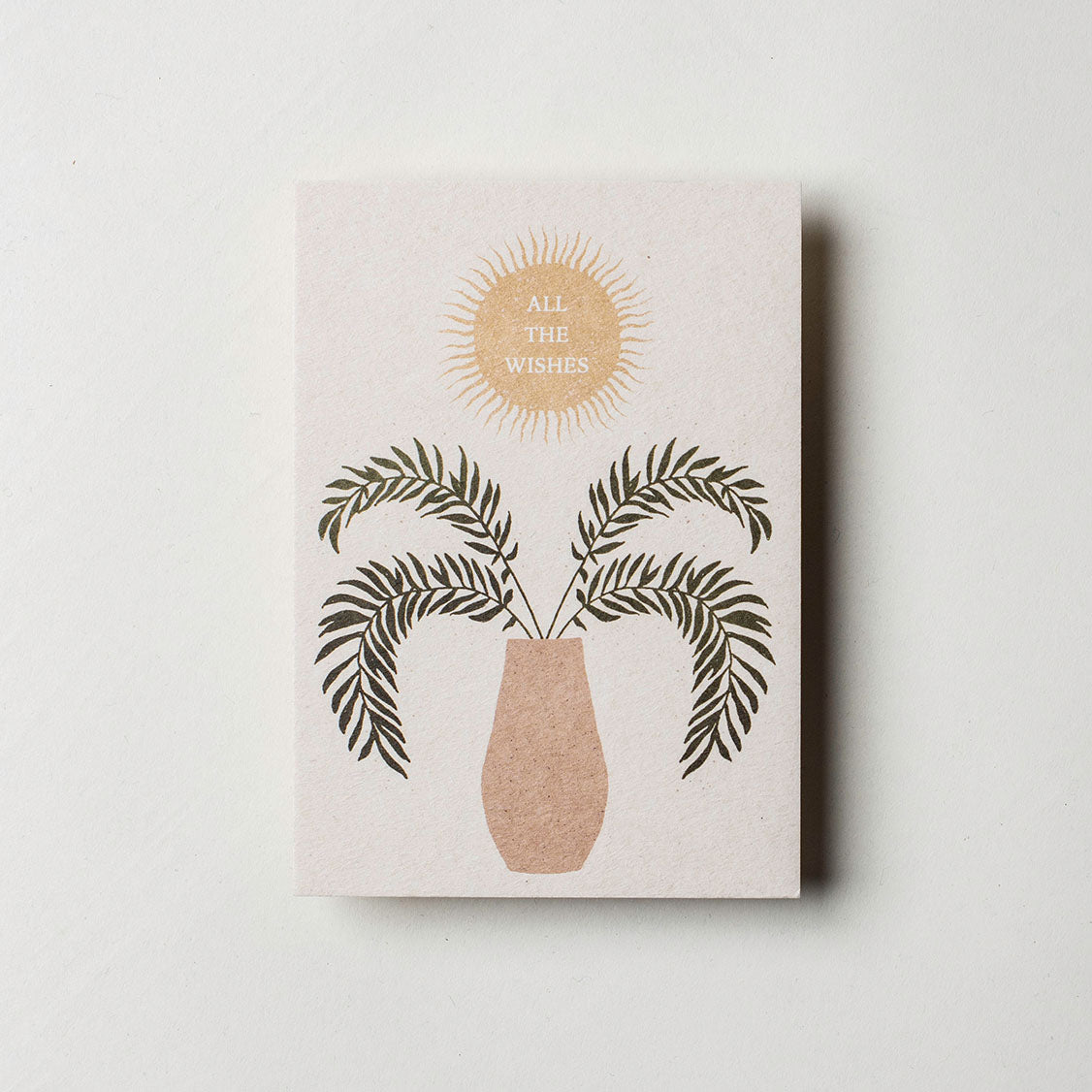 Postkarte bedruckt mit einer Pflanze und einer Sonne, in der steht "All the Wishes". Das Design von Anna Cosma ist auf einer DIN A6 Finnpappe gedruckt.