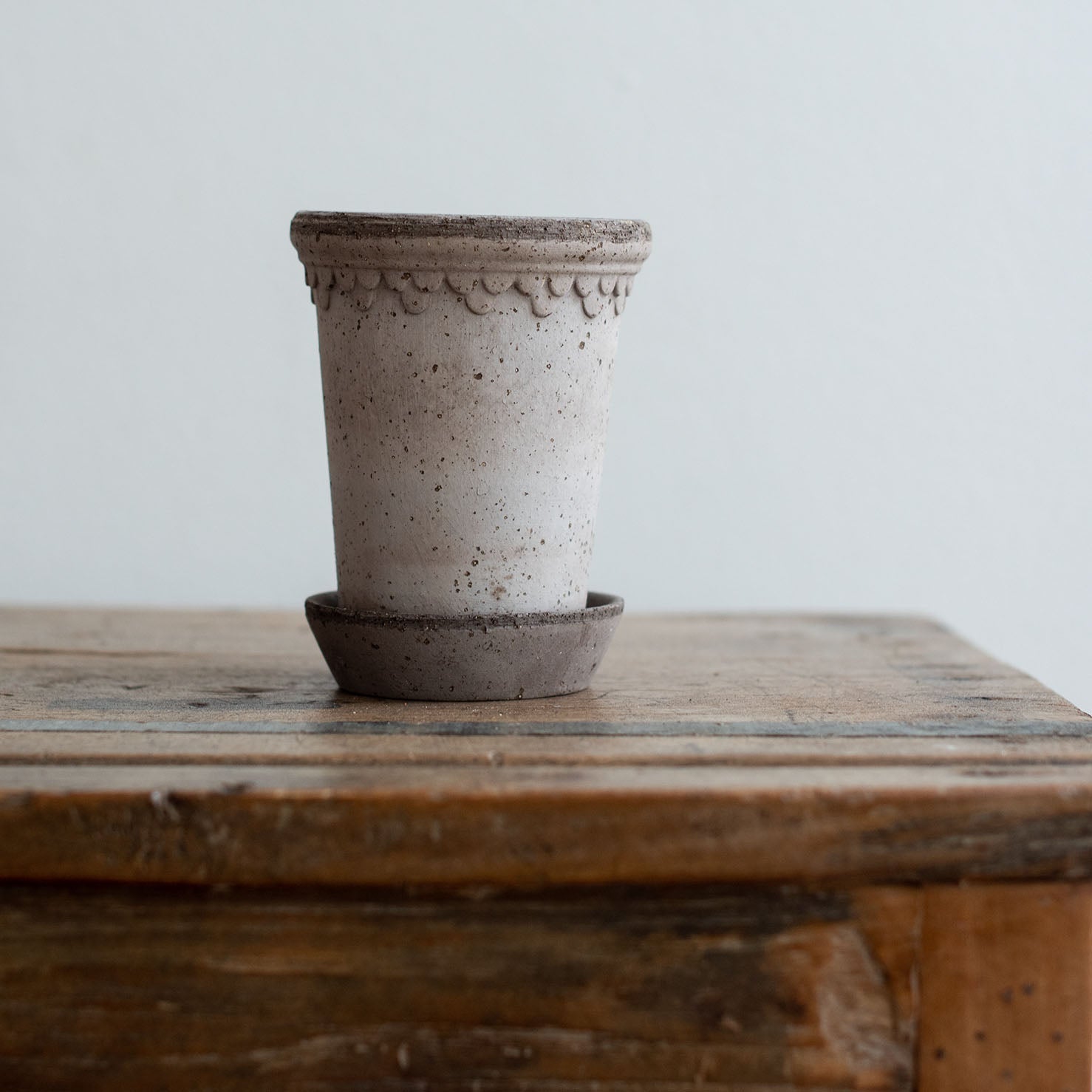Nahaufnahme eines grauen Keramik Blumentopf mit Untersetzer. Kopenhagener Topf, der auch als Schlosstopf von Bergs bekannt ist, hergestellt von Bergs Potter.