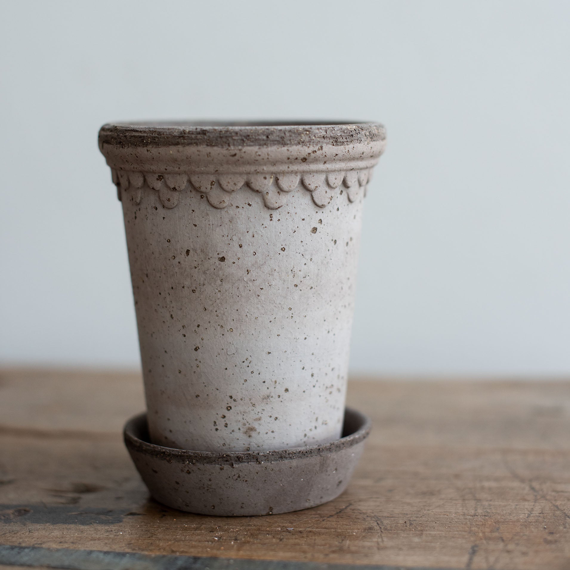 Nahaufnahme eines grauen Keramik Blumentopf mit Untersetzer. Kopenhagener Topf, der auch als Schlosstopf von Bergs bekannt ist, hergestellt von Bergs Potter.